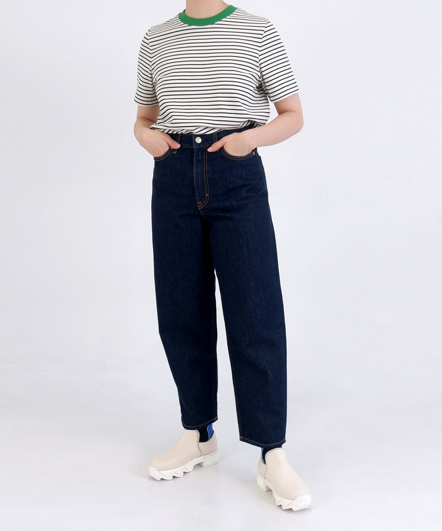 A model casually posing with WES III Sand Low Top Sneaker, styled with simple straight cut denim pants and striped t-shirt